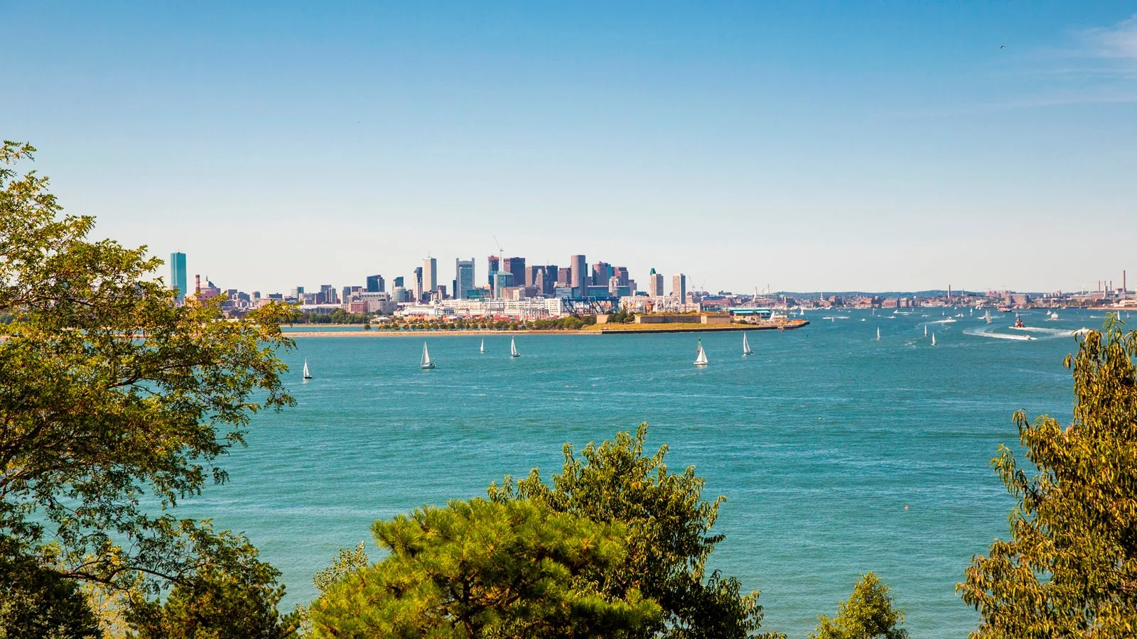 Boston skyline across the harbor with sailboats, demolition and masonry contractor